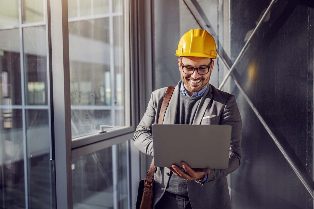 Construction manager using laptop at building site