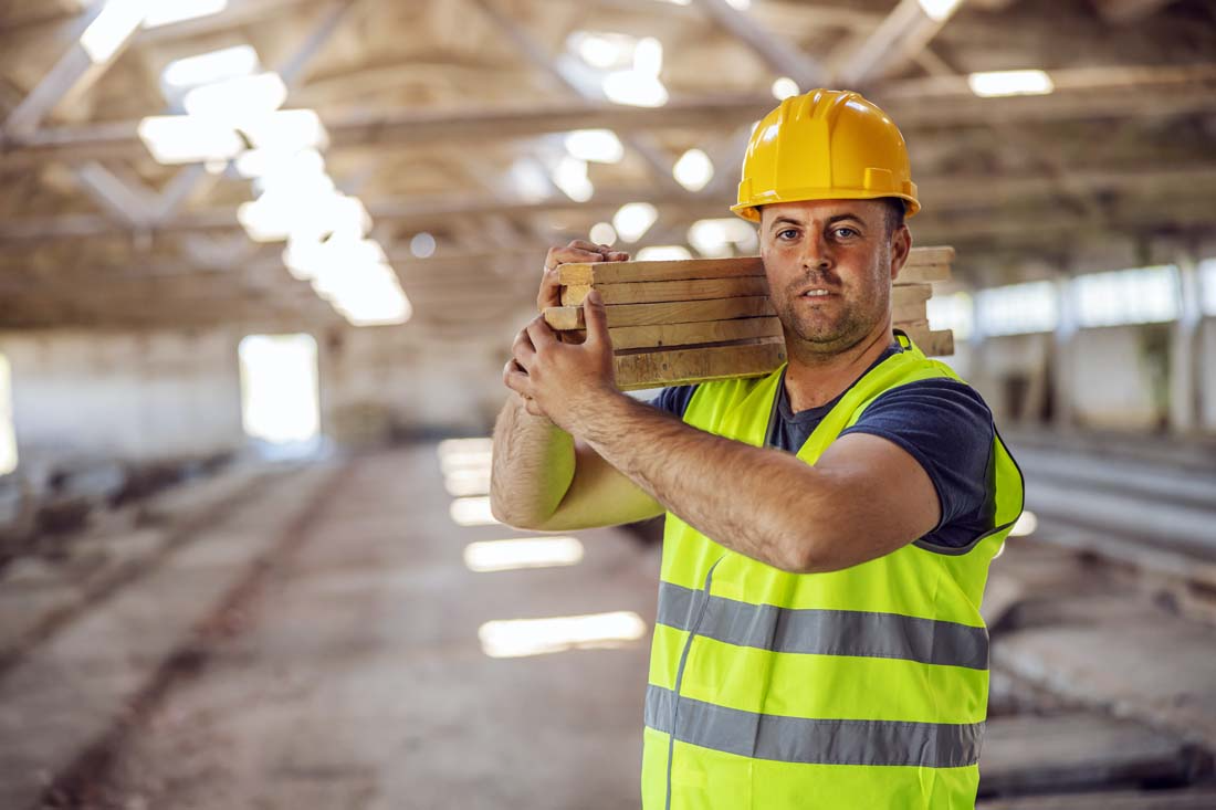 blog-image-0061 | Fast Labour Hire Construction worker carrying wooden planks indoors