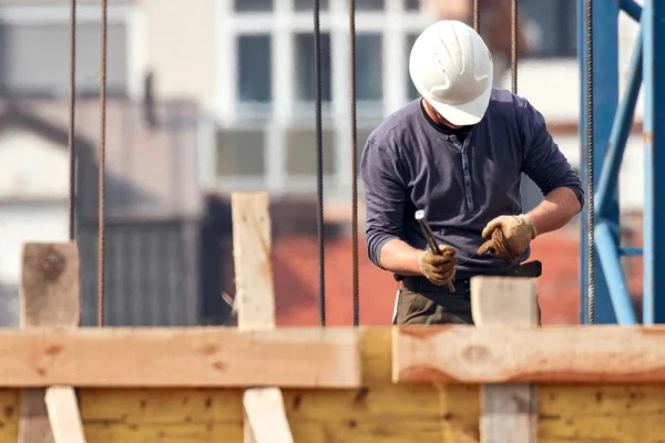 Worker in hard hat using tools at a construction site