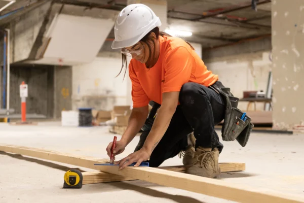 Worker measuring wood.