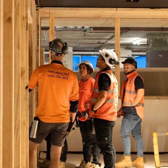 2-B-1 | Fast Labour Hire Four construction workers in safety gear talk on site.